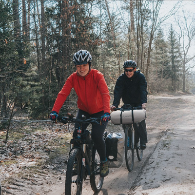 Couple randonnée vélo tente bivouac fixée devant guidon