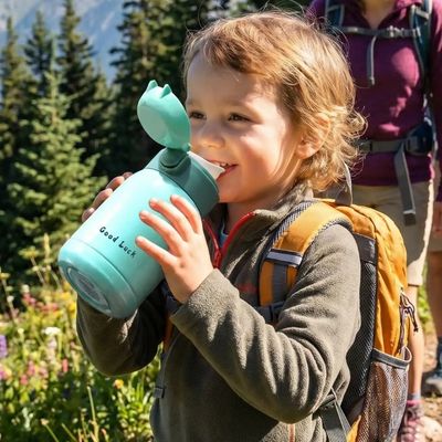 Enfant boit dans petite gourde isotherme adaptée main enfant
