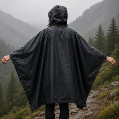 Femme cape de pluie randonnée ample sous averse