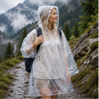 Femme couverte poncho jetable protège pendant balade montagne