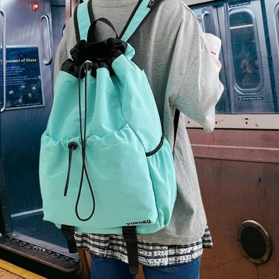 Fille devant train sac de voyage enfant sur dos