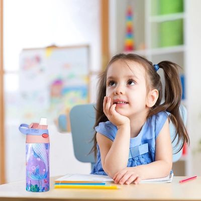 Fillette assise table rêve gourde isotherme enfant posée côté