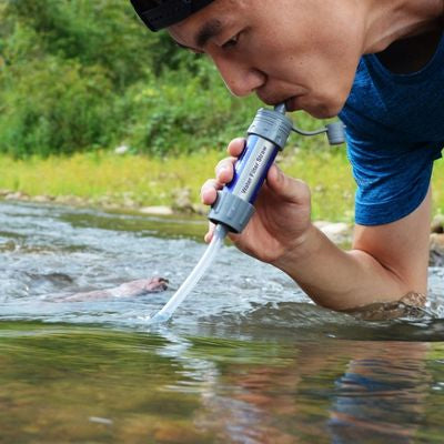 Homme boit eau avec filtre à eau et prolongateur