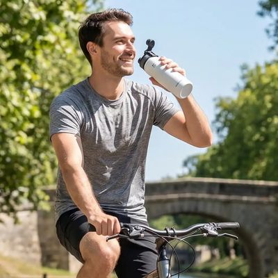 Homme boit gourde isotherme pour vélo pendant balade vtc