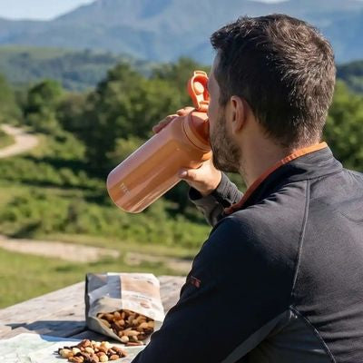Homme boit gourde isotherme sport assis table pique-nique
