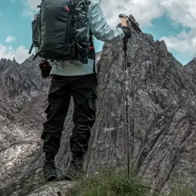 Homme devant montagne batons randonnée rocher