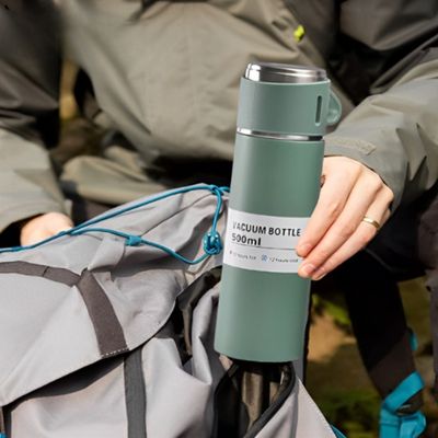 Homme insert thermos avec tasse dans sac à dos