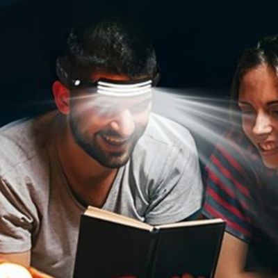 Homme lit avec lampe frontale bandeau LED allonge extérieur tente