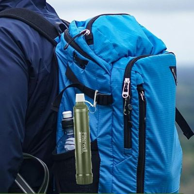 Homme marche avec filtre à eau accroché côté sac