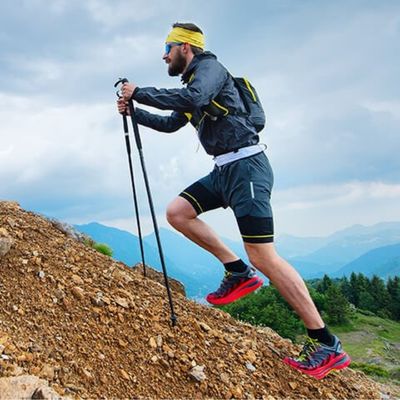 Homme monte montagne avec batons pour marche nordique