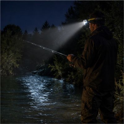 Homme pèche de nuit avec lampe frontale puissante professionnelle