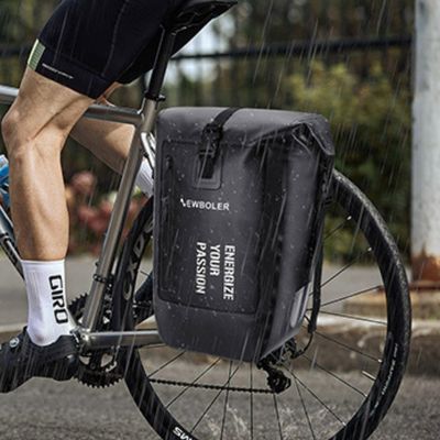 Homme pédale pluie une des sacoches vélo attachée