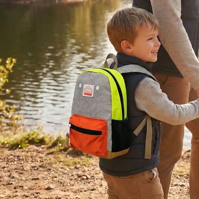 Jeune garçon sac a dos enfant maternelle accroché père
