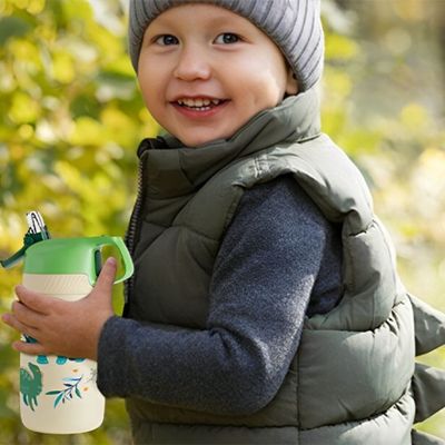 Petit garçon heureux gourde isotherme enfant en mains