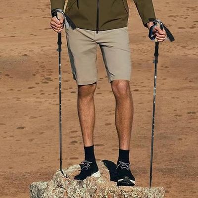 Randonneur équilibre rocher avec baton en trail